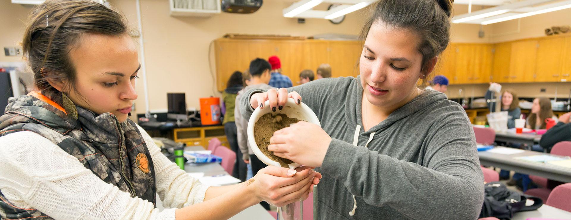 Agriculture students measuring soil into beaker