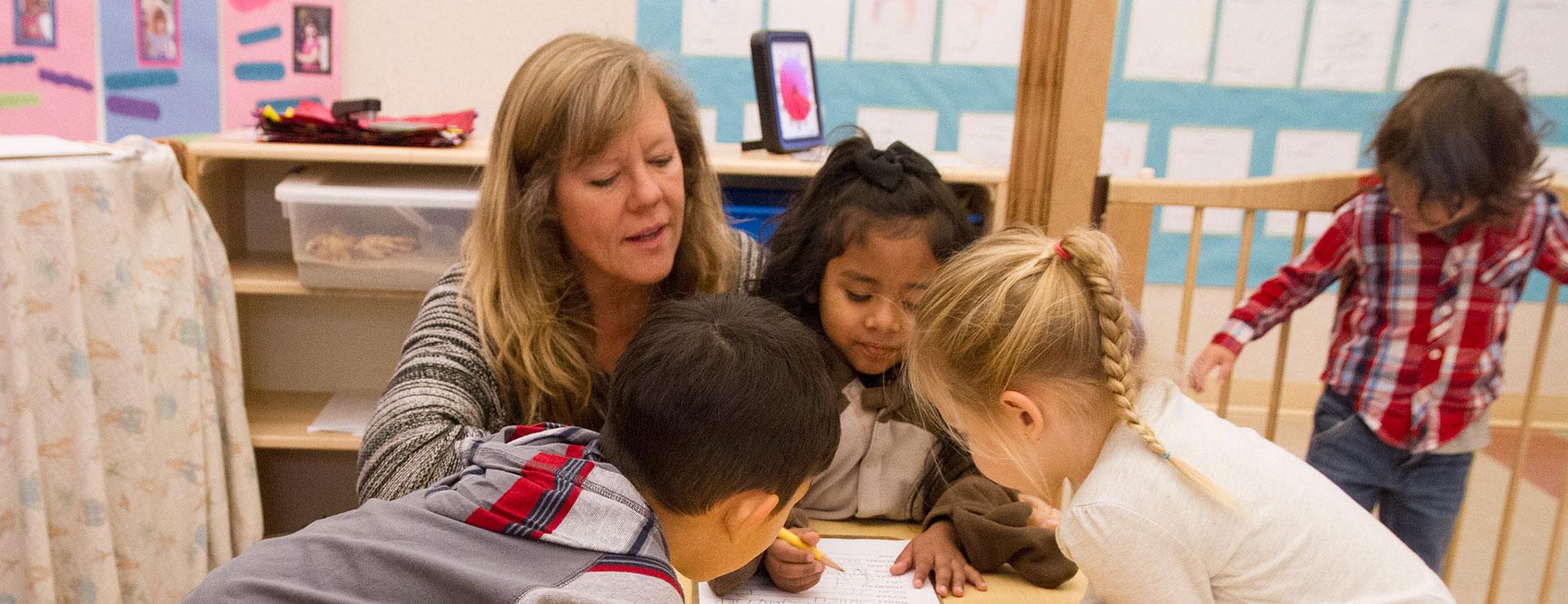 Preschool instructor teaching and playing with preschool children