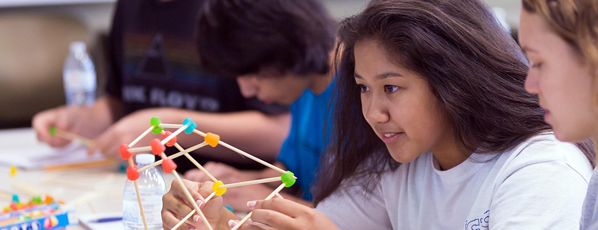 Engineering students working on structures using Dots candies and skewers