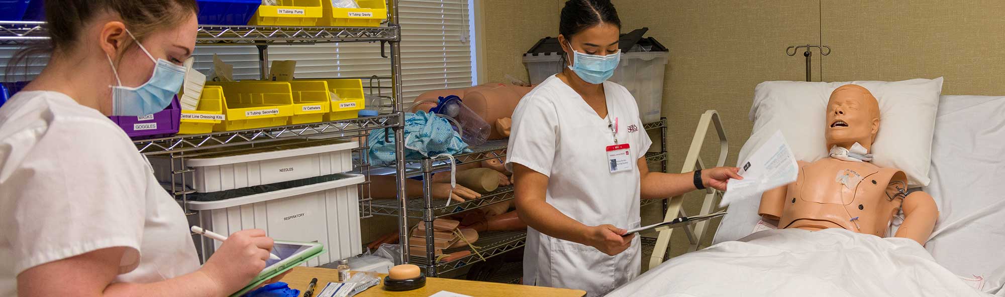 Nursing students practicing techniques using simulated patient