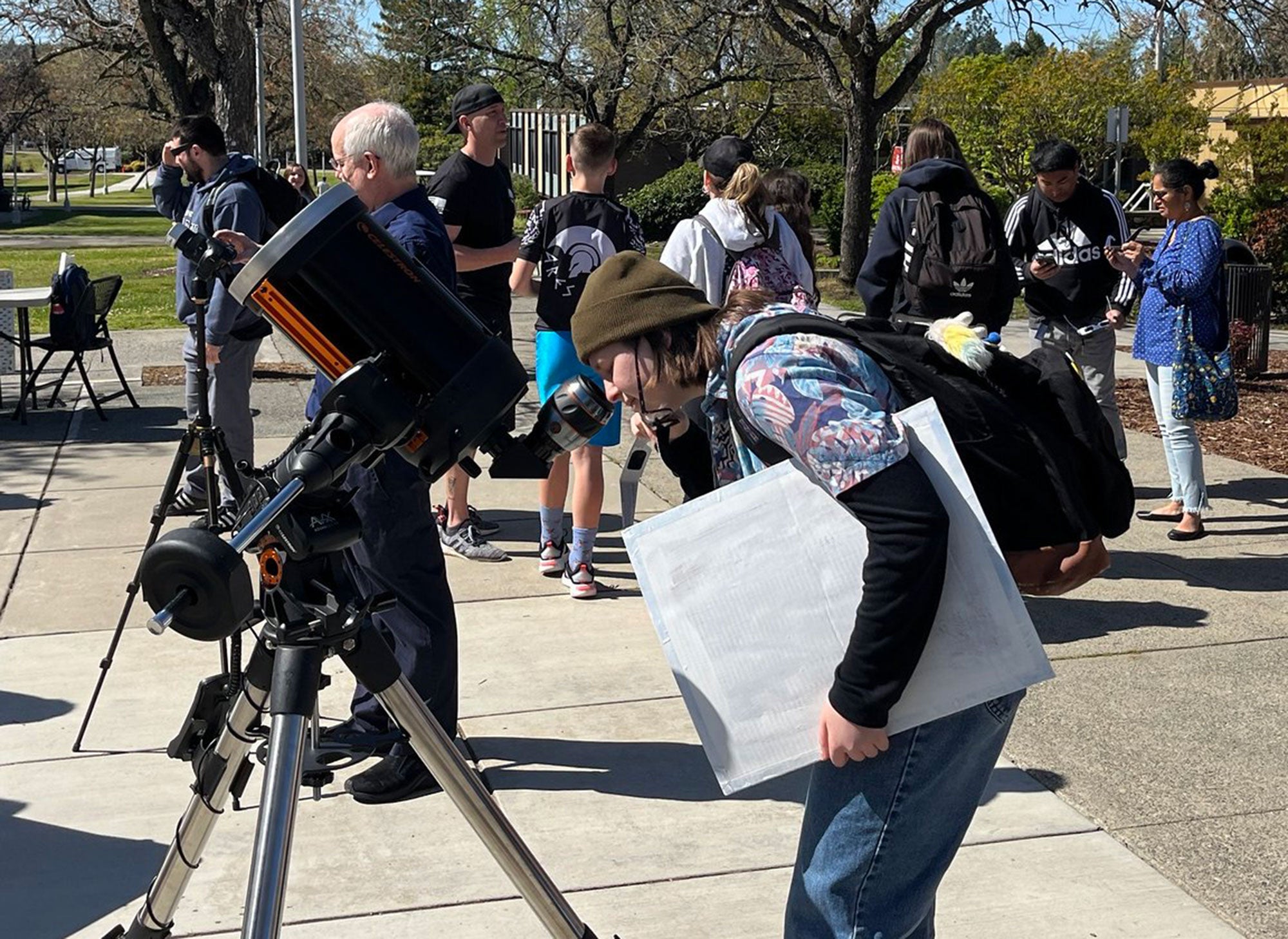 Student using telescope on campus