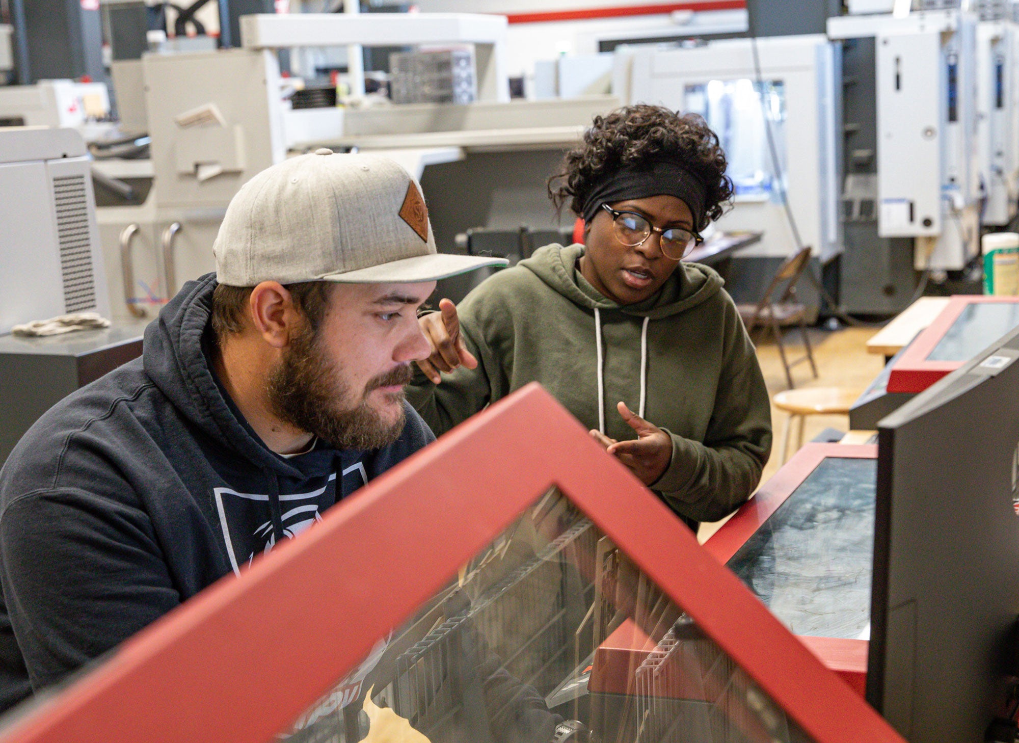 Two entrepreneurial students using large printer in Makerspace on Rocklin Campus