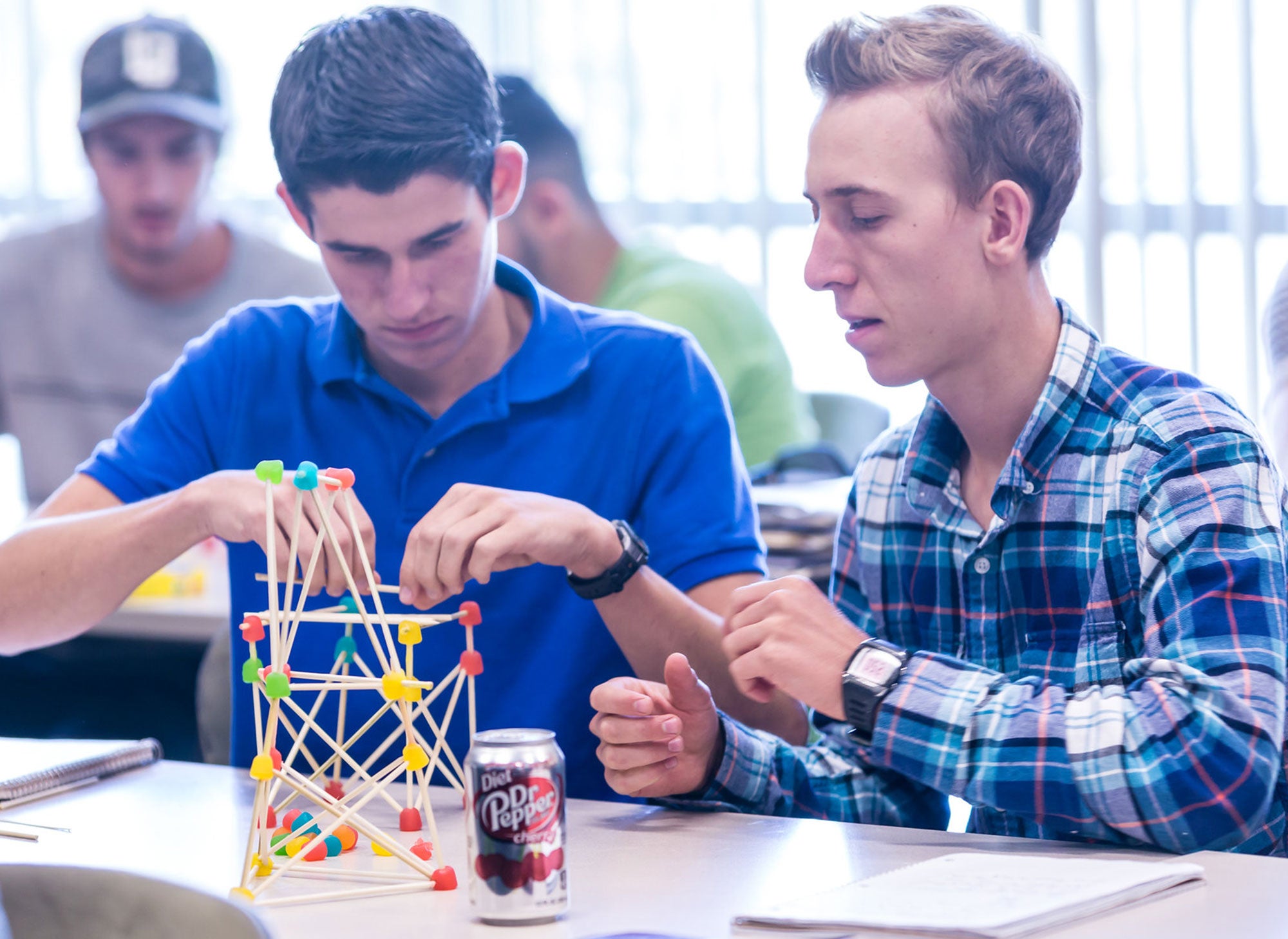 Two engineering students building structure with toothpicks and gumdrops
