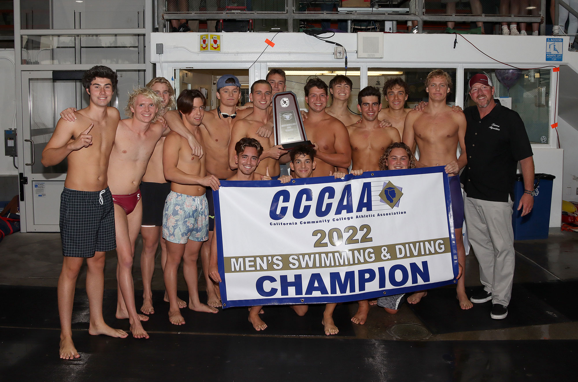 Group photo of Sierra College men's swimming team holding state champion banner