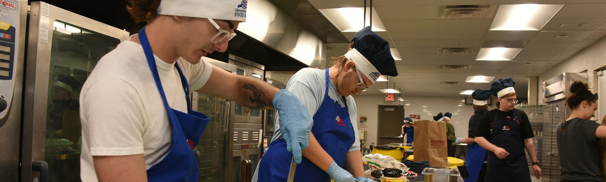 Students learning culinary skills in commercial kitchen