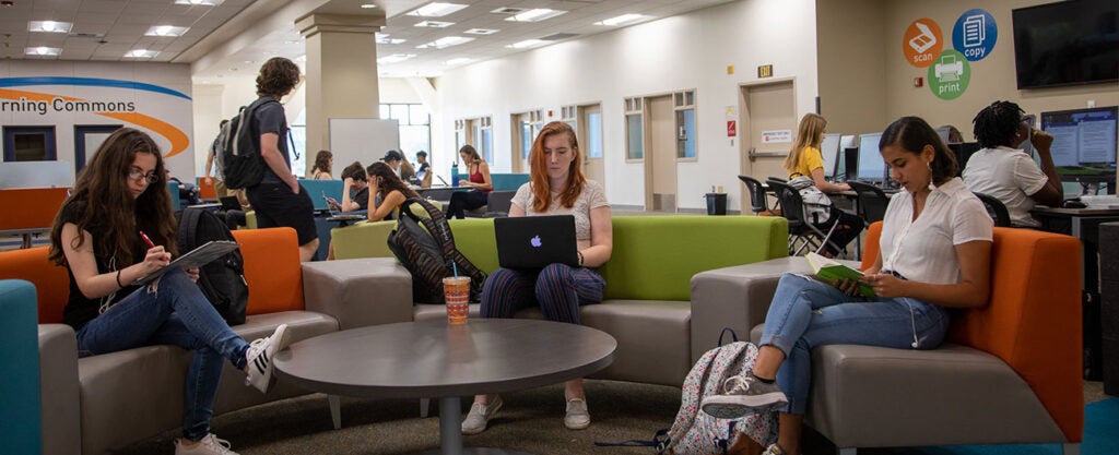 Students sittiing on couches in Student Tech Support area of the library