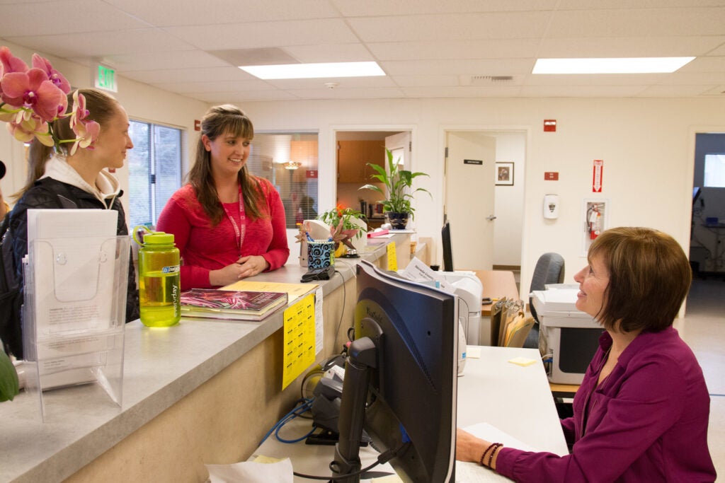 Students standing at the receptionist desk