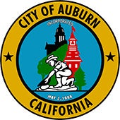 Auburn City Seal a circle with gold miner, courthouse and schoolhouse