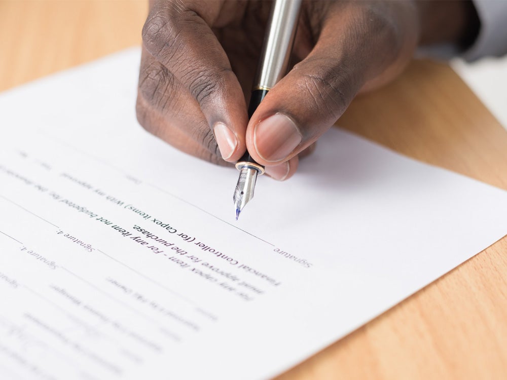 Man is signing a page