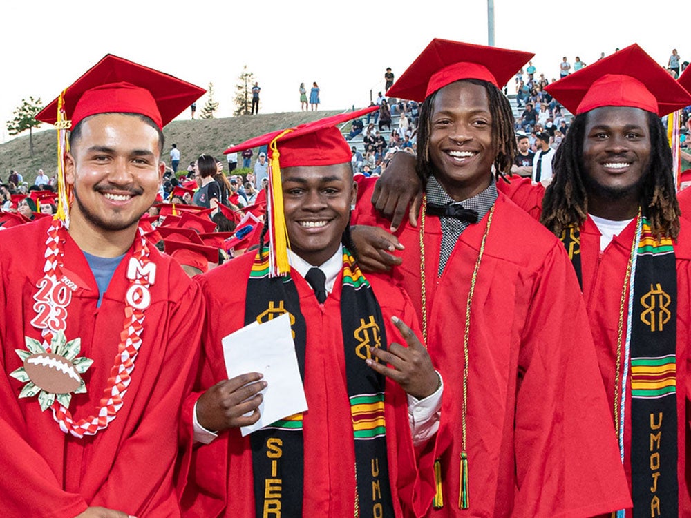 Two Sierra College graduates dressed in graduation attire