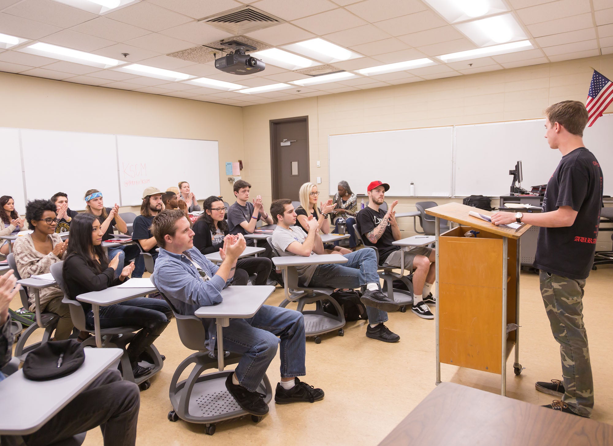 Communication Studies And Journalism student gives a speech in front of the class at the podium