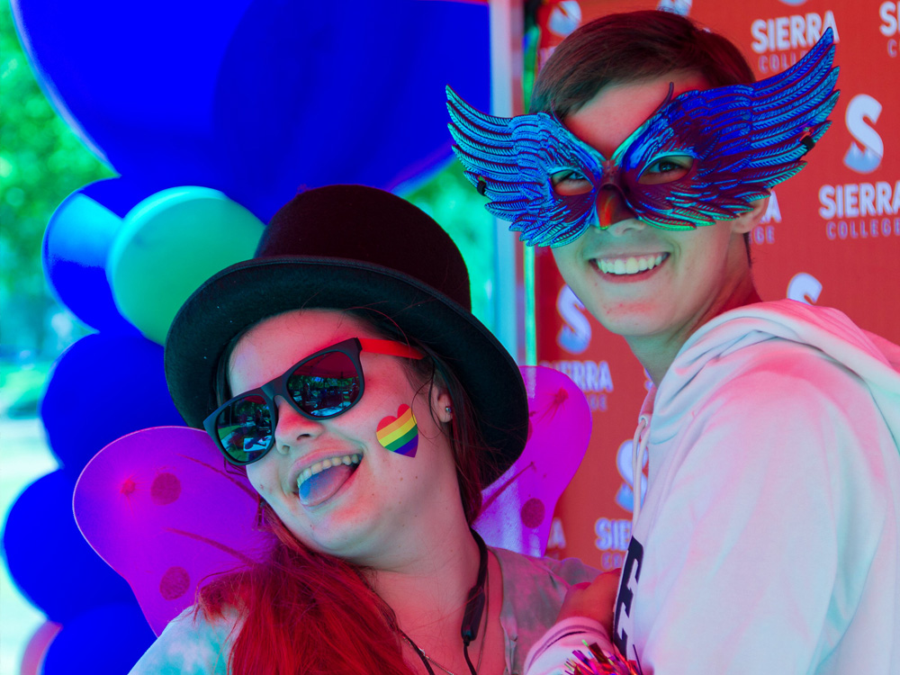 Two student with happy faces and masks on an event