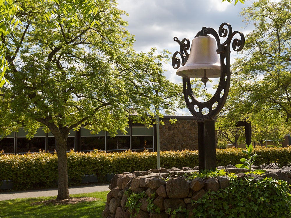 Brass bell positioned in a stone circular base on the Sierra College Rocklin campus