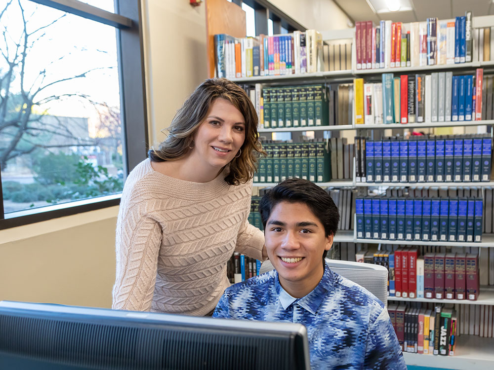 Sierra College library staff helping student with research guides on computer