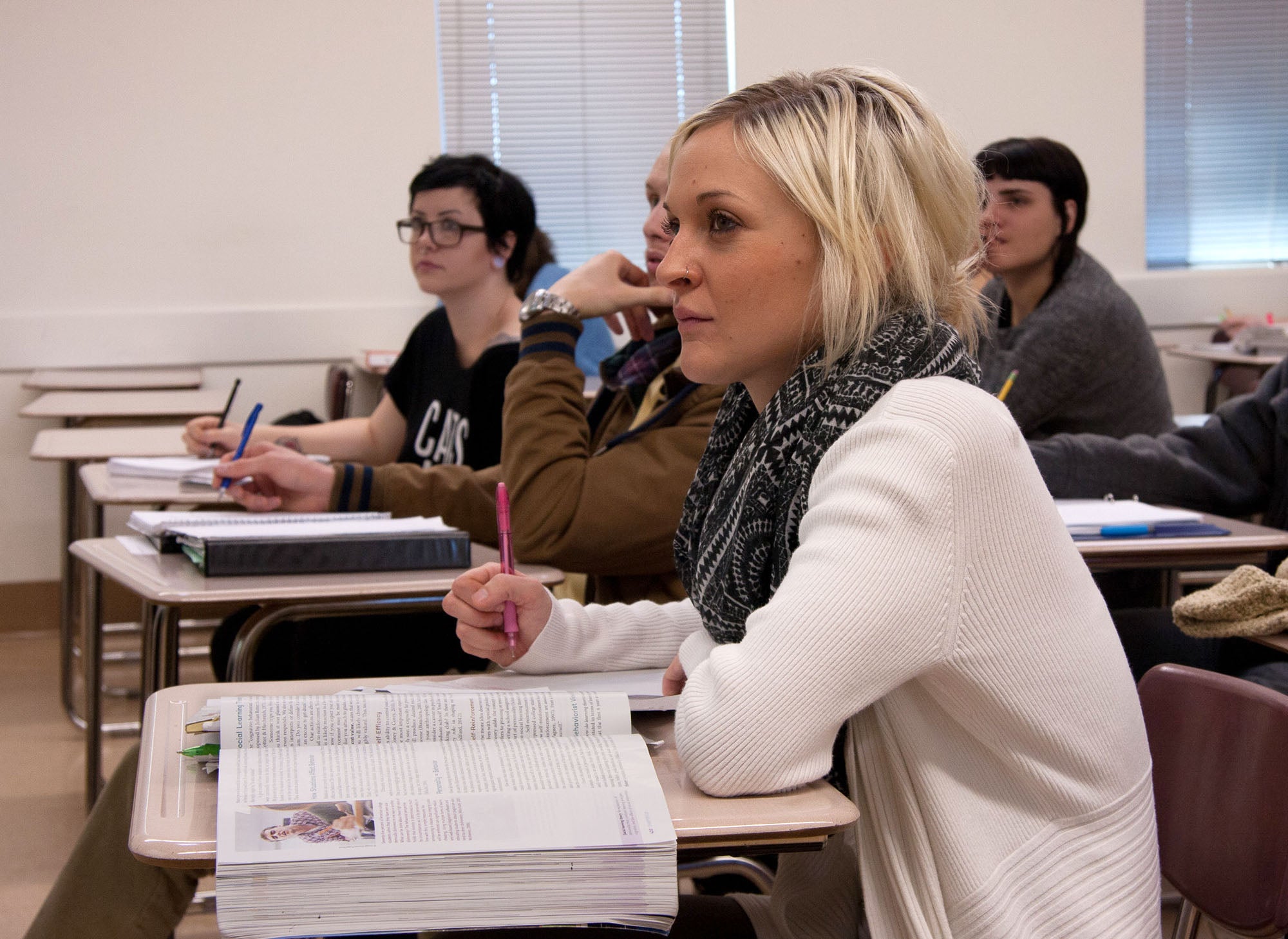 Psychology student in class with textbook