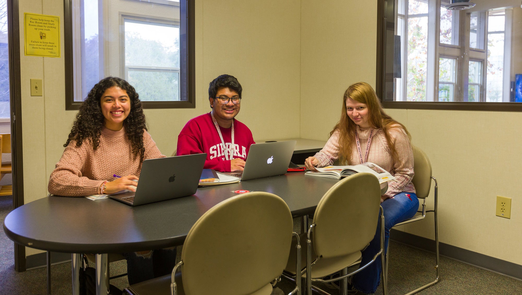 Three students sitting at the table studying