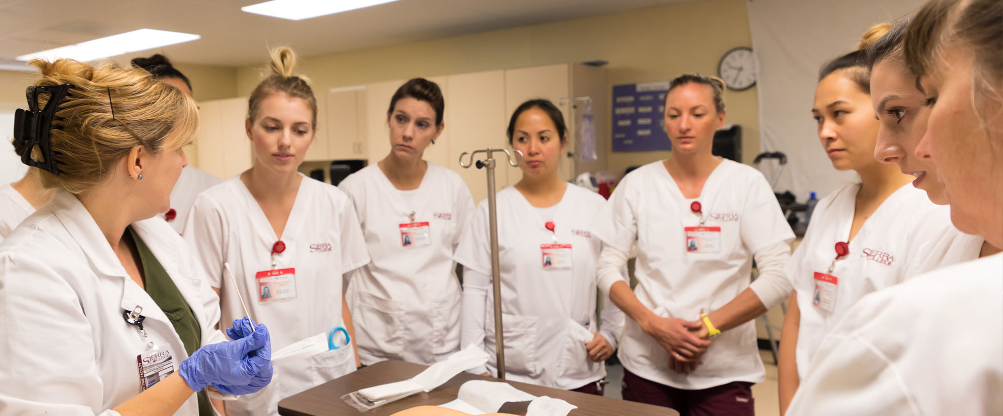 Nursing instructor explaining procedure to nine students in Sierra Nursing Village