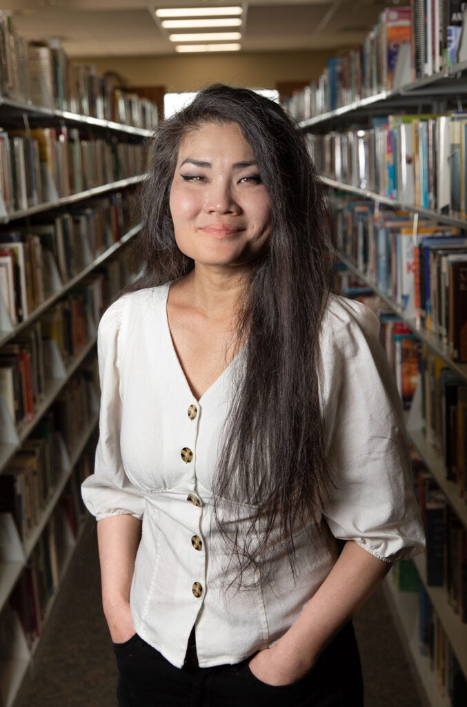 Dr Jane Skaife, sociology instructor standing in book aisle of Rocklin library