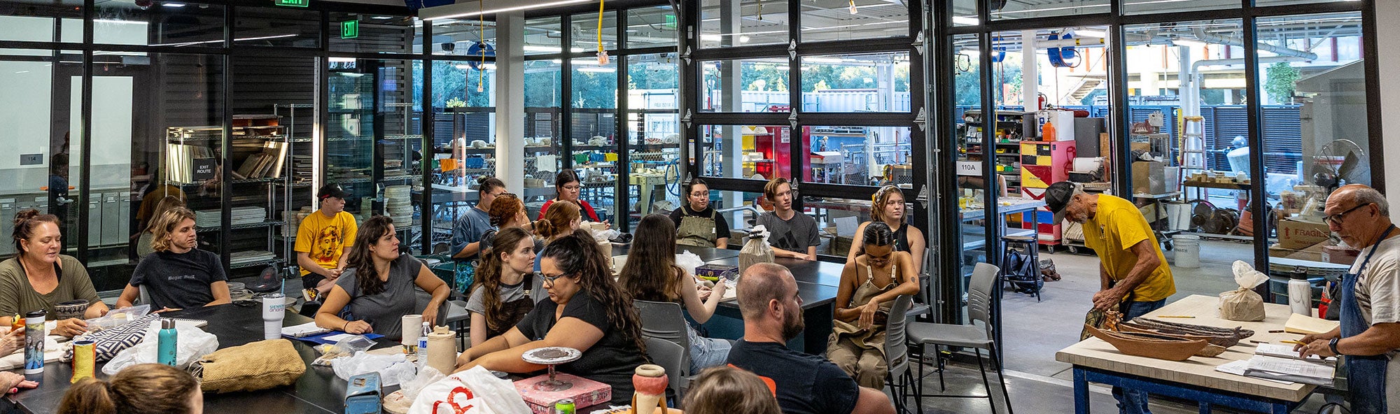 Art instructor (far right) talking to students in ceramic class.