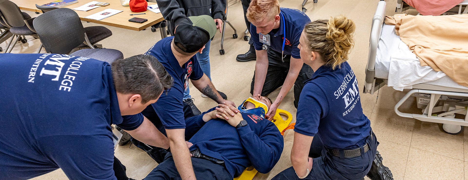 Allied Health students sitting at desks in classroom wearing Sierra College navy blue EMT polo shirts