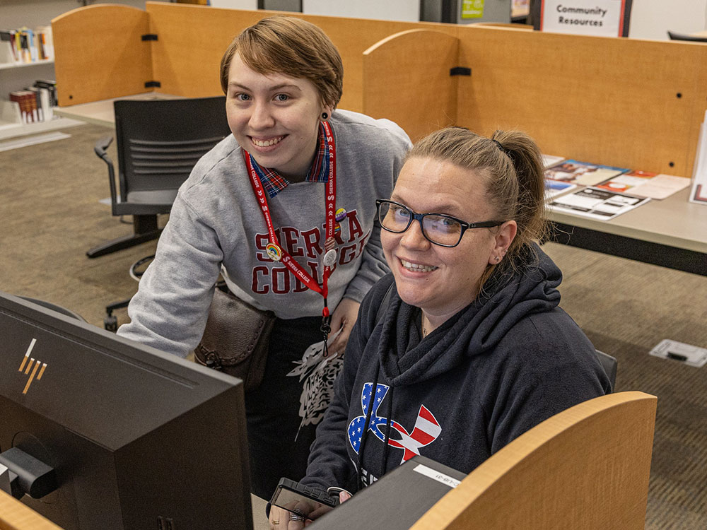 Student receiving help from library staff member