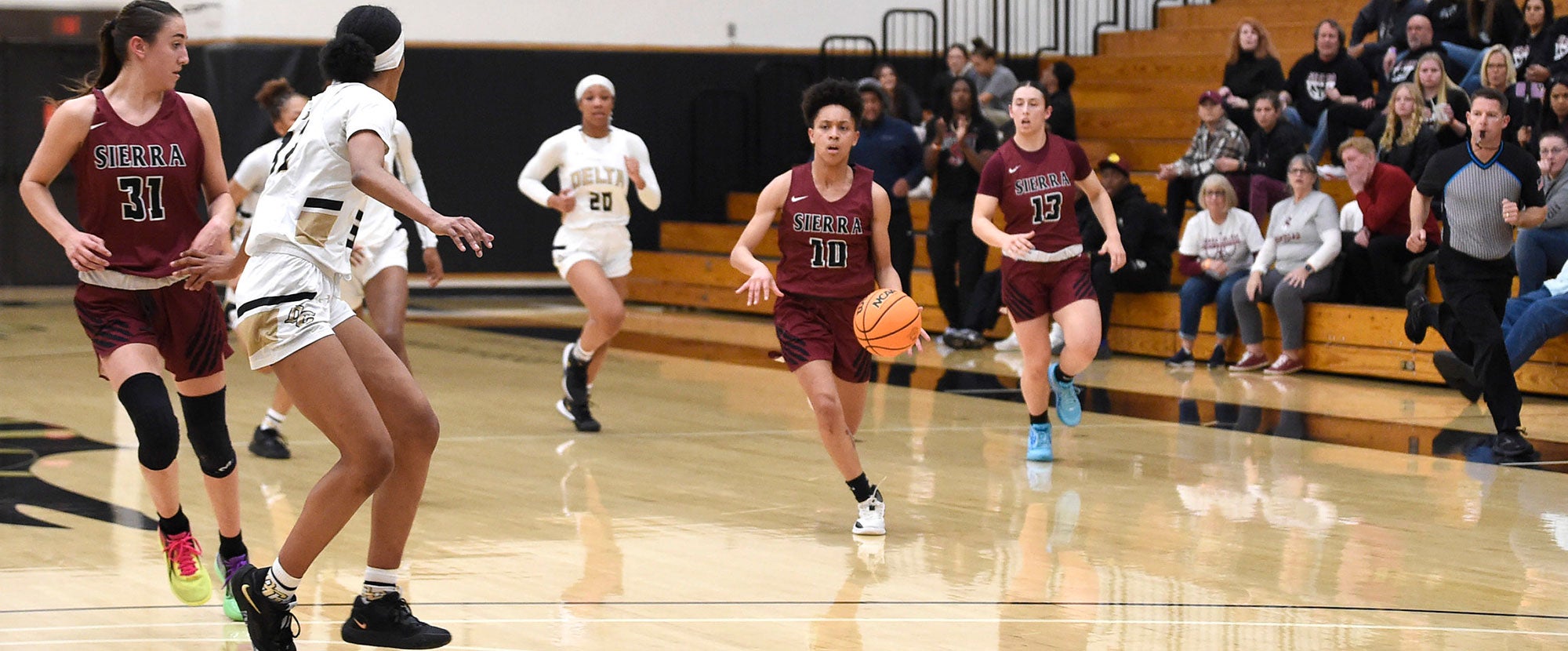 Sierra College woman basketball player dribbling ball toward net