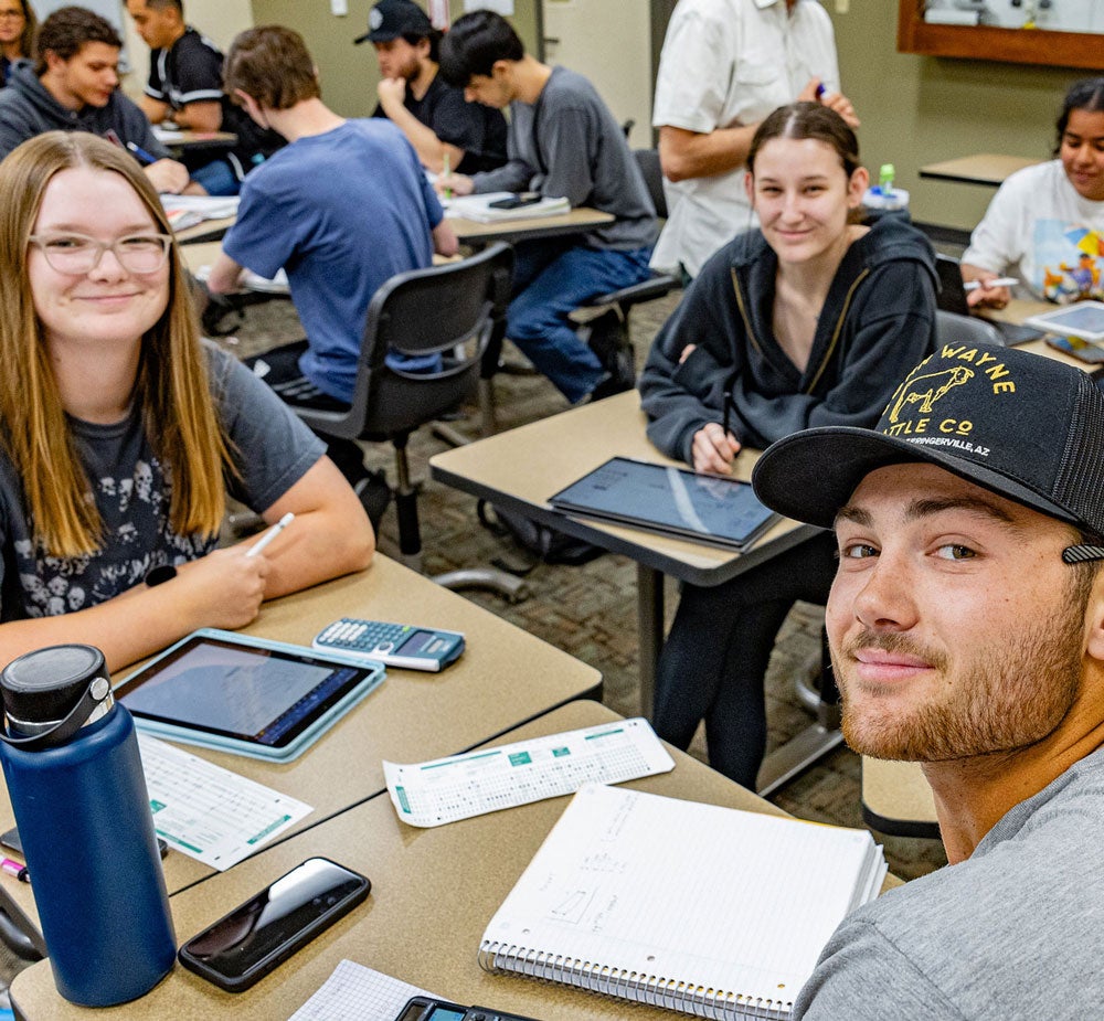 Four physics students working in group in classroom