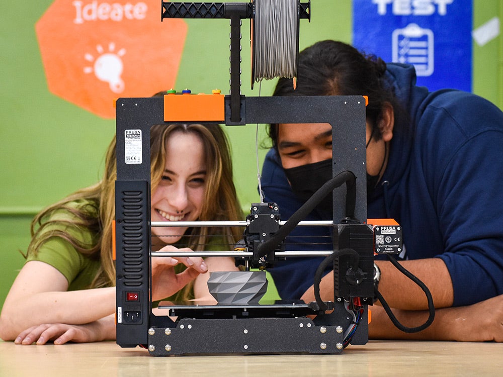 Two students using 3D printer in the MakerSpace