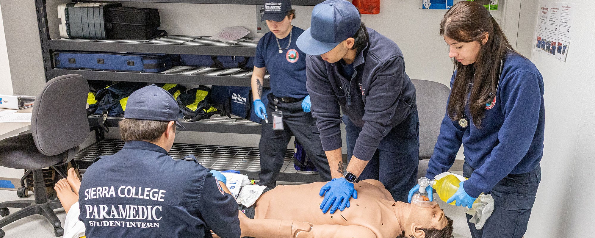 Paramedic student interns practice on simulator patient.