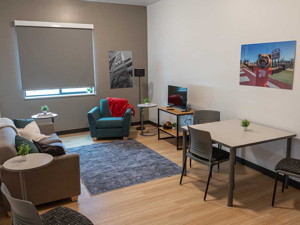 Student housing living room includes couch and dining table.