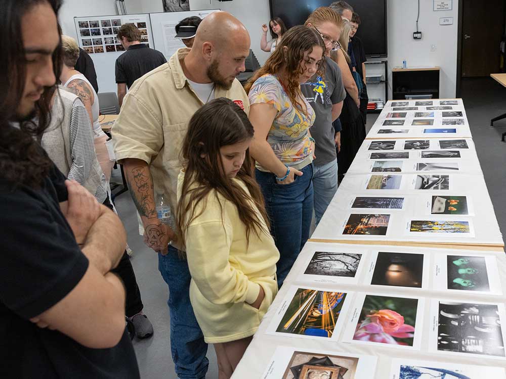 Visual and Performing Arts (VAPA) attendees look at photography on display